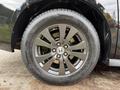 A close-up of a black alloy wheel from a 2014 Honda Odyssey featuring five spokes and the Honda logo on the center cap
