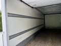 Interior of a 2020 Hino 338 truck with blank walls and wooden flooring showcasing metal tie rails for securing cargo