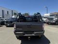A 2010 Toyota Tacoma truck with a black exterior and an open bed, showing the truck's rear with no tailgate attached