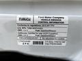 A 2015 Ford Transit with a vehicle emission control label detailing compliance information and fuel specifications