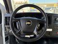 Steering wheel of a 2014 Chevrolet Express with a central Chevy logo and buttons for audio and cruise control