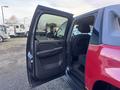A red 2011 Chevrolet Avalanche with the driver's side door open showcasing the interior and seating