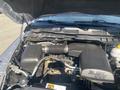 The engine compartment of a 2021 RAM 1500 showing the 36L VVT engine with various components including the air intake and battery