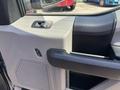 The interior door panel of a 2015 Ford F-150 featuring a window control switch and a door handle
