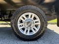 Close-up of a silver wheel with a chrome hubcap on a 2019 Ford F-350 SD featuring rugged black tire tread