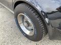 A close-up of a black 1972 Chevrolet Corvette tire with a shiny rim and a radial tire clearly showing the brand name and size