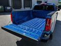 A blue 2021 Chevrolet Colorado truck with the tailgate down revealing a clean, lined truck bed designed for hauling and storage