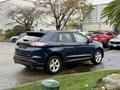 A blue 2017 Ford Edge SUV parked with its rear facing the viewer showcasing its sleek design and modern features