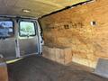 Interior view of a 2012 Chevrolet Express van featuring wooden paneling and storage boxes on the floor