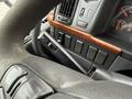 Close-up of the steering wheel and dashboard controls in a 2012 Volvo VNL with various buttons and a gear shift lever visible