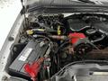 The image shows the engine compartment of a 2008 Ford F-450 SD with visible components like the battery various hoses and an engine part in red