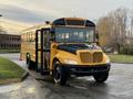 A 2013 International 4300 school bus painted yellow with a black front and open door