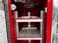 Interior storage compartments of a 1991 Sutphen Deluge fire truck with metal shelves and red trim