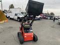 A 2024 AGT Industrial LRT23 compact loader with a raised bucket and tracks positioned on a paved surface