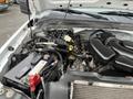 The engine compartment of a 2010 Ford F-250 SD showcasing the battery, wiring harness, and various engine components