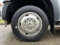 Close-up of a 2011 Ford F-550 tire and wheel showcasing a five-bolt pattern and metallic finish with deep tread on the tire