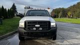 Front view of a white 2007 Ford F-550 truck with a black grille and two circular lights mounted on the bumper