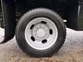 A close-up view of a white steel wheel with a black tire designed for a 2008 Sterling Bullet showing the tire tread and lug nuts