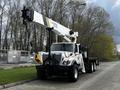 A 2008 International 7500 truck equipped with a crane mounted on the chassis and a flatbed, showcasing a white and black color scheme