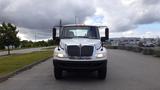 A 2015 International DuraStar 4300 truck viewed from the front with a white facade and distinct large grill