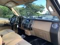 Interior of a 2013 Ford F-450 Super Duty with beige seats and dashboard featuring a central control console and radio system