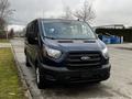 A 2020 Ford Transit van in dark blue color parked with its front facing the viewer showing the grille and headlights