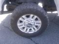 A close-up of a silver alloy wheel from a 2018 Ford F-350 SD featuring a rugged tire tread design
