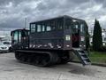 A 2023 Prinoth Panther T6 tracked vehicle with a cabin featuring several windows and an accessible rear stairway