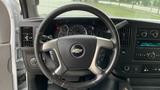 The interior view of a 2017 Chevrolet Express Quigley 4x4 showing the steering wheel with controls and dashboard gauges