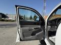 A 2015 Toyota Tacoma with an open driver's side door showing the interior door panel and dashboard