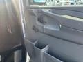 Interior door panel of a 2013 Chevrolet Express featuring a handle window control and storage compartments