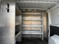 Interior of a 2017 RAM Promaster van featuring metal shelving units along the walls and a clear floor space