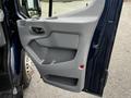 Interior door panel of a 2017 Ford Transit 350 showing a gray plastic design with a handle and storage compartment