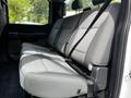 Interior view of the backseat of a 2024 Ford F-550 with three gray cloth seats featuring seatbelts and a spacious design