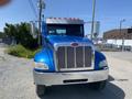 A 2008 Peterbilt 340 truck in blue with chrome accents and a large front grille is shown facing forward with dual side mirrors and orange clearance lights on top