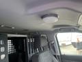 Interior view of a 2016 Chevrolet Tahoe showing the driver's seat and a partition behind it with a metal grate