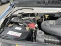 A close-up view of the engine compartment of a 2009 Ford Econoline showing the battery and several fluid reservoirs and hoses