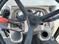 Steering wheel and control panel of a 2010 Kubota M6040 with dials levers and compartments for tools and fuel
