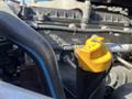 A yellow oil dipstick cap on a 2022 Freightliner Cascadia engine with various engine components and hoses visible in the foreground
