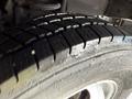 Close-up of a tire from a 2012 Ford Econoline showing tread pattern and surface details with some water droplets