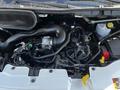 Engine compartment of a 2022 Ford Transit showcasing various components like hoses and electronic parts
