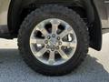 A close-up of a shiny silver wheel with large treads mounted on a 2022 RAM 3500 truck