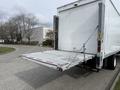 A 2017 Hino 338 box truck with a lowered rear liftgate for loading and unloading cargo
