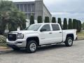 A white 2016 GMC Sierra 1500 pickup truck parked with a double cab and chrome accents
