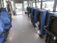 Interior of a 2020 Chevrolet Express with blue seats aligned on both sides and metal mechanisms for seat adjustment visible