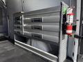 A 2017 Mercedes-Benz Sprinter interior with a metal storage unit featuring multiple drawers and a fire extinguisher mounted on the side
