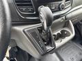 Close-up of the gear shift lever of a 2023 Ford Transit with gear selection options P R N D M and a leather boot around the base