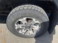 A close-up of a tire and wheel from a 2014 Ford F-150 showing a chrome wheel with intricate design and a rugged tire tread pattern
