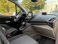 Interior of a 2019 Ford Transit Connect showing the dashboard with a touchscreen display gear shift and seating area