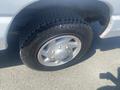 A 2009 Ford Econoline with a close-up view of its tire and wheel showcasing the tread pattern and rim design